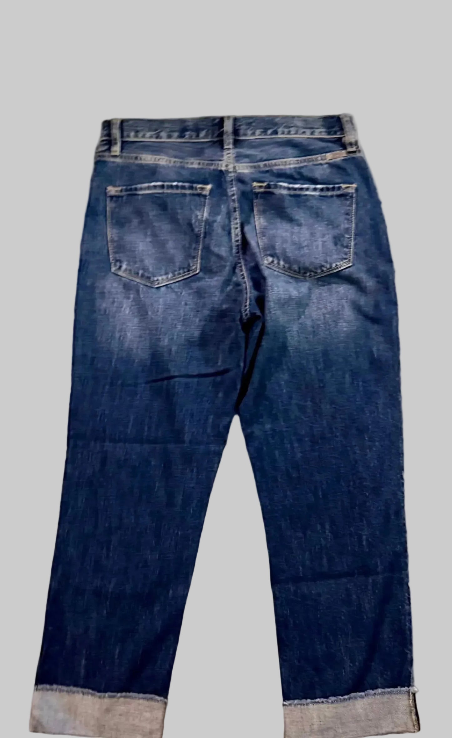 Back view of a pair of blue jeans on a white background