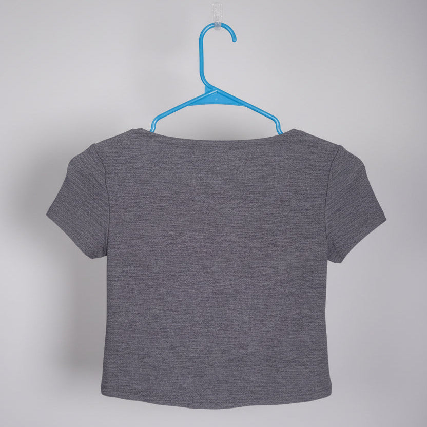 Gray t-shirt on a hanger with a blurred indoor background