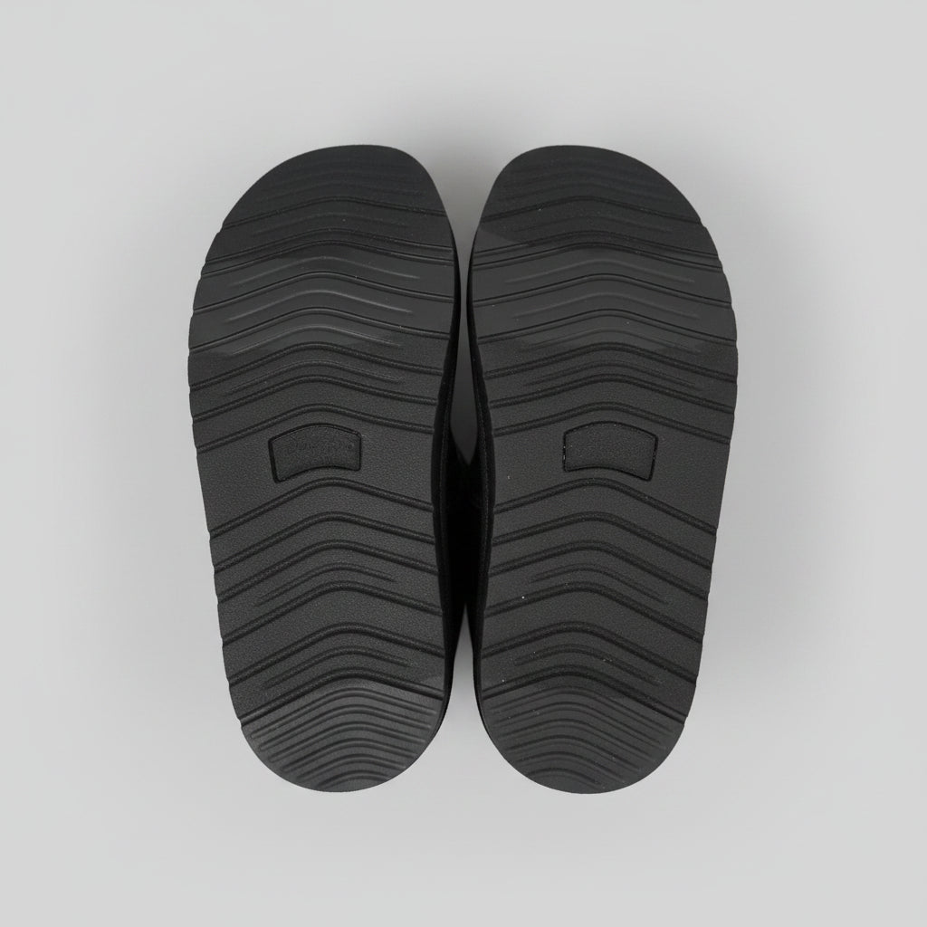 Black shoe soles on a light gray background