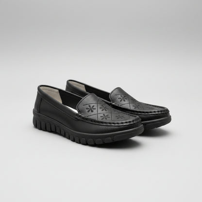 Black shoes on a beige surface with a blurred background