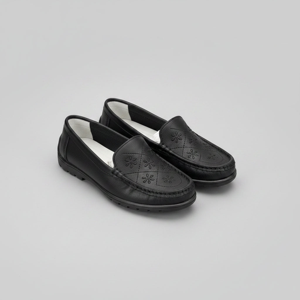 Black loafers with a light gray background