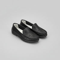 Black loafers with a light gray background