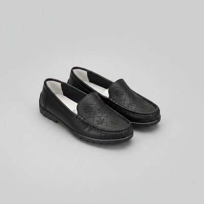Black loafers with a light gray background