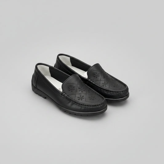 Black loafers with a light gray background