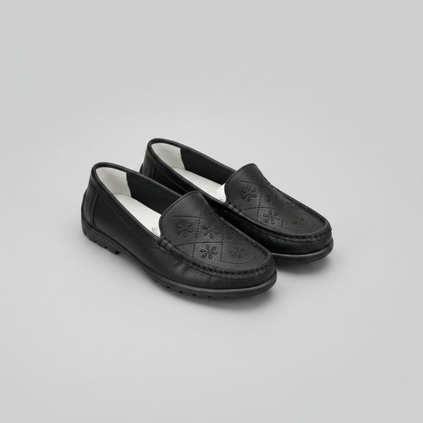 Black loafers with a light gray background