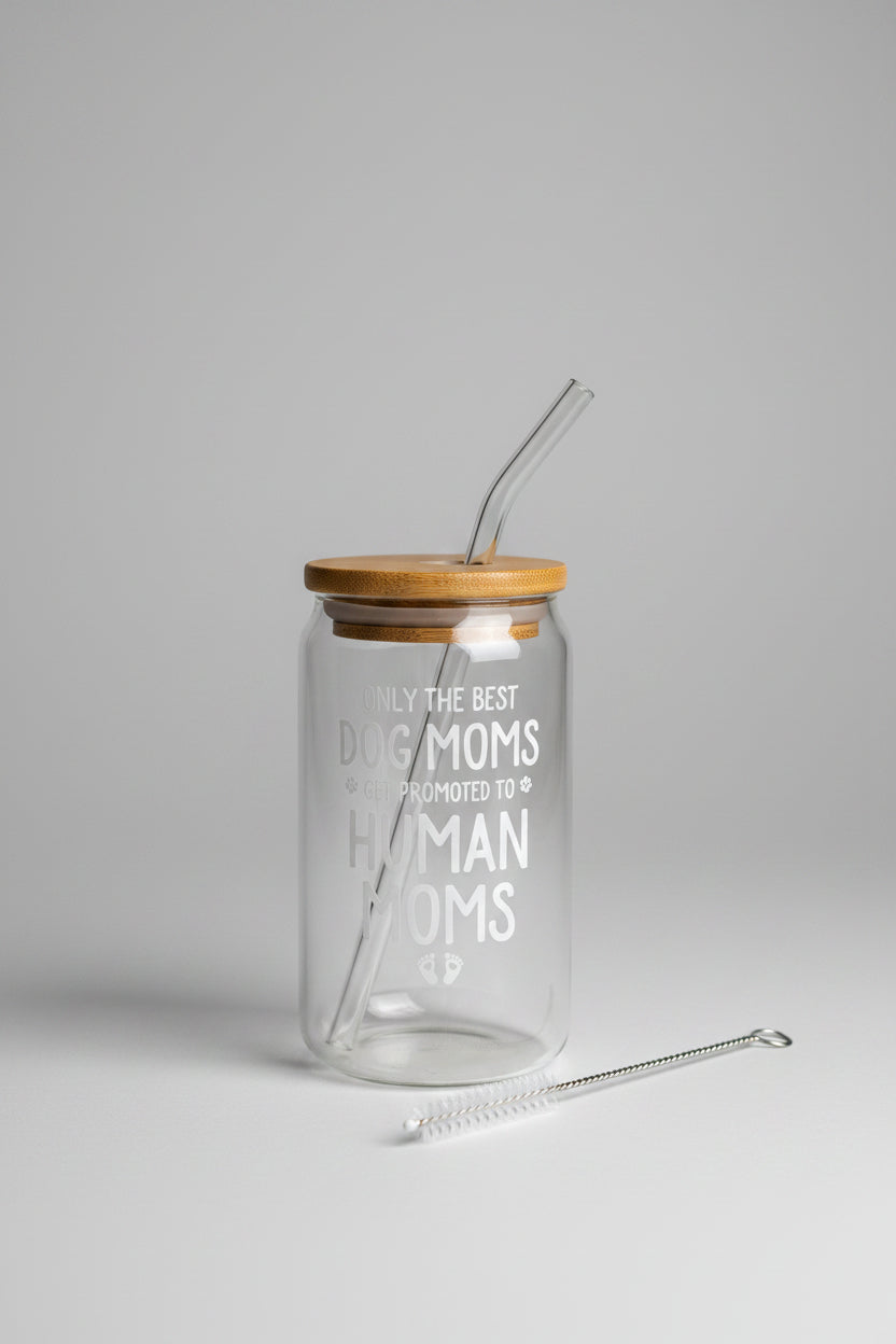 Glass jar with straw and text 'Only the best dog moms get promoted to human moms' in a cardboard box.