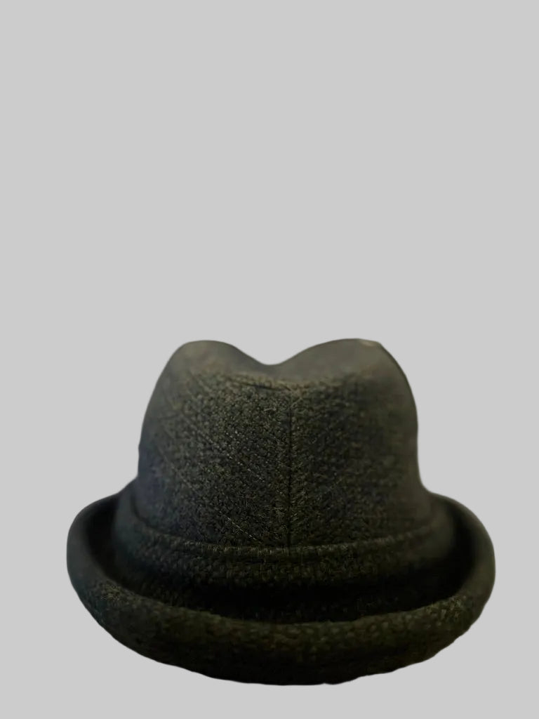 Dark gray fedora hat on a carpeted floor with a blurred background
