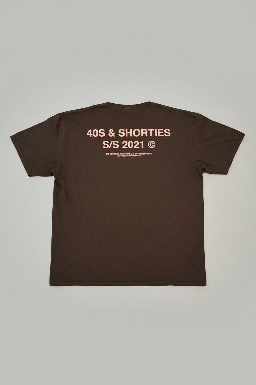 Brown t-shirt with text on the back on a textured gray background