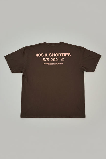 Brown t-shirt with text on the back on a textured gray background