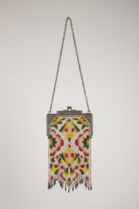 Decorative handbag with intricate beadwork on a textured surface