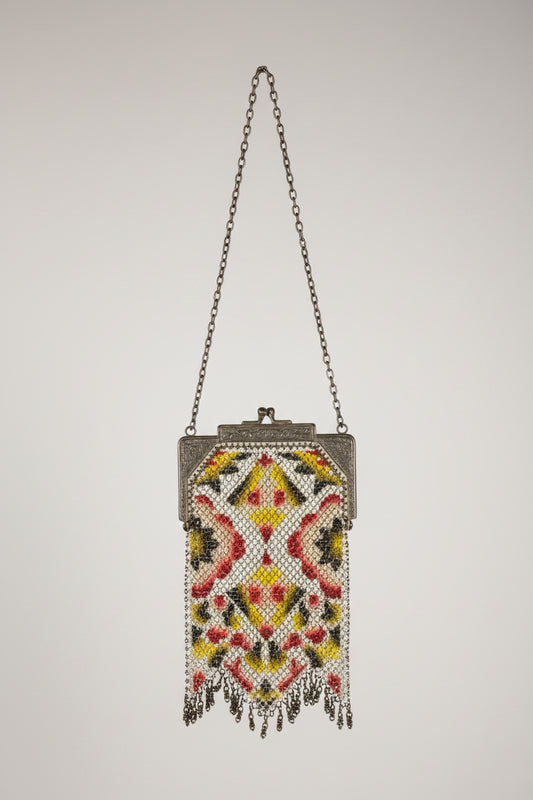 Decorative handbag with intricate beadwork on a textured surface