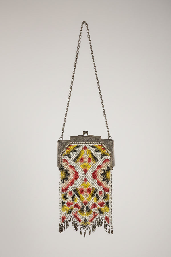 Decorative handbag with intricate beadwork on a textured surface