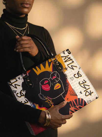 Person holding a colorful handbag with a stylized face design against a blurred background