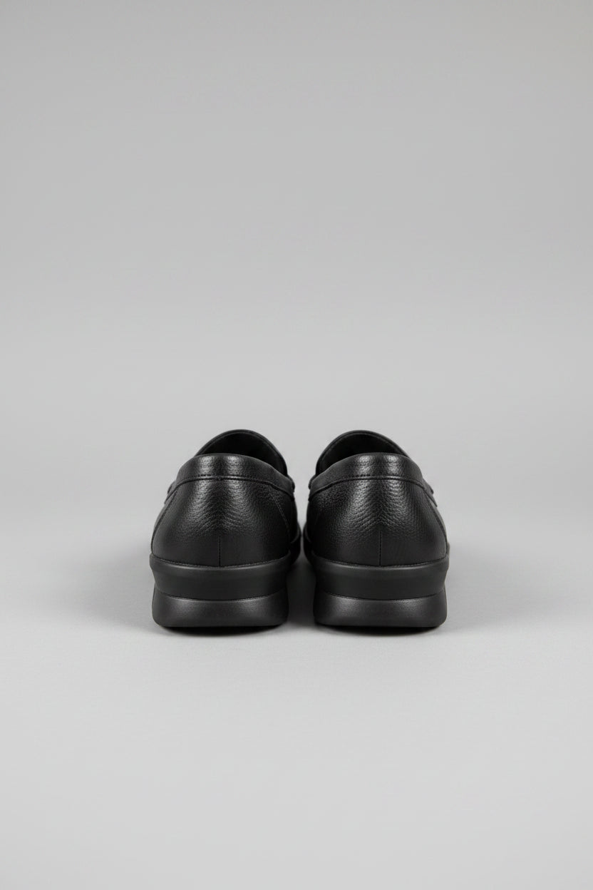 Pair of black shoes on a wooden surface with a blurred background