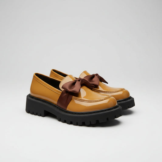Yellow shoes with brown bows on a white towel, blurred indoor background