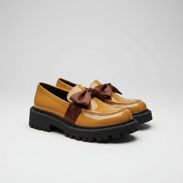 Yellow shoes with brown bows on a white towel, blurred indoor background