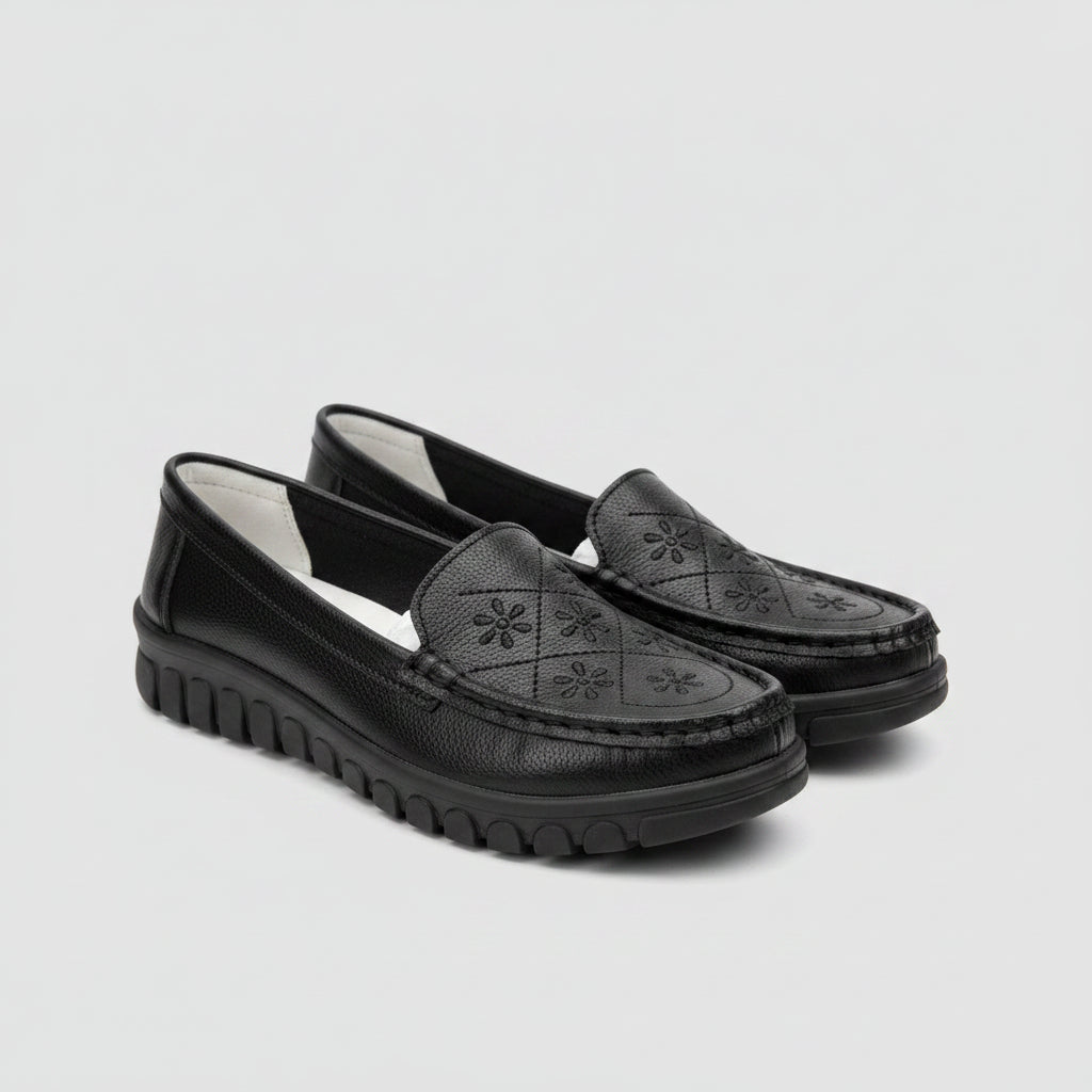 Black loafers on a light-colored surface with a blurred background