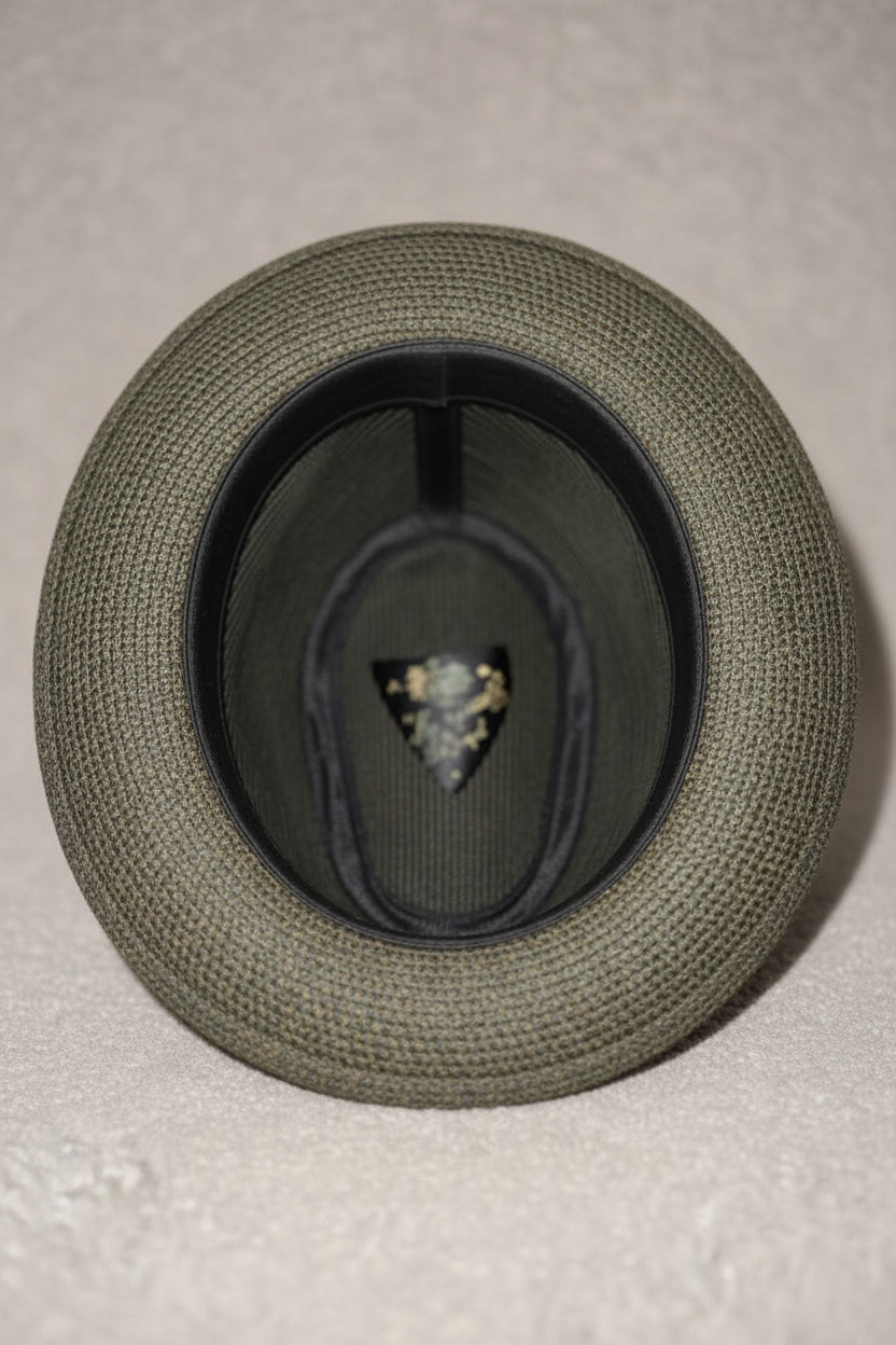 Gray hat with a brand logo on a beige surface