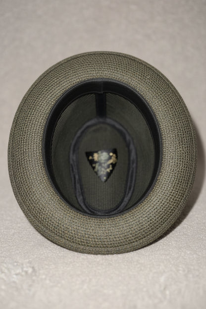 Gray hat with a brand logo on a beige surface