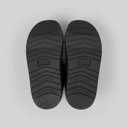 Black shoe soles on a light gray background