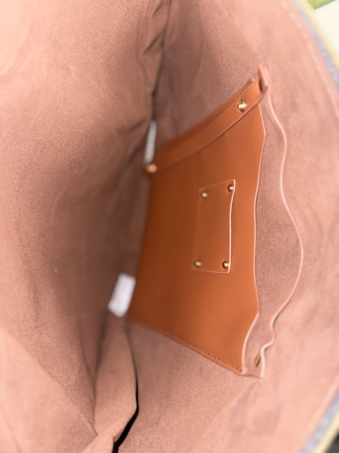 Close-up of a brown leather patch on a beige fabric surface