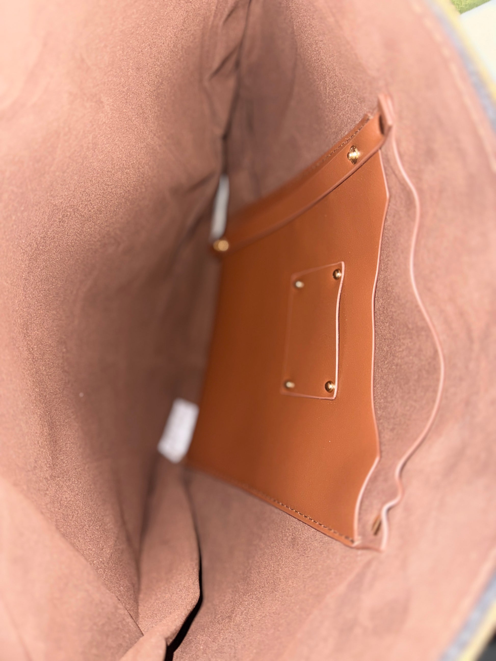 Close-up of a brown leather patch on a beige fabric surface