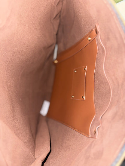 Close-up of a brown leather patch on a beige fabric surface