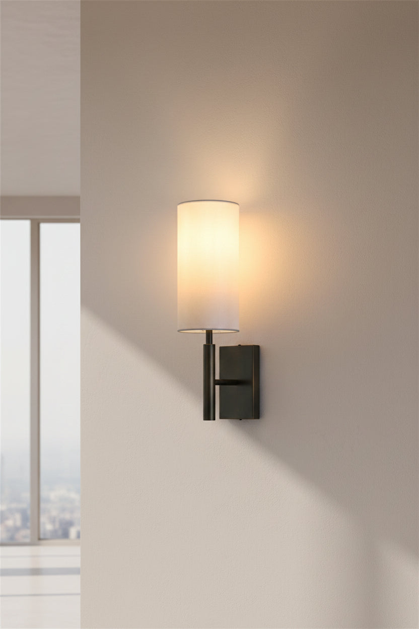 Wall-mounted lamp with a white shade on a plain wall